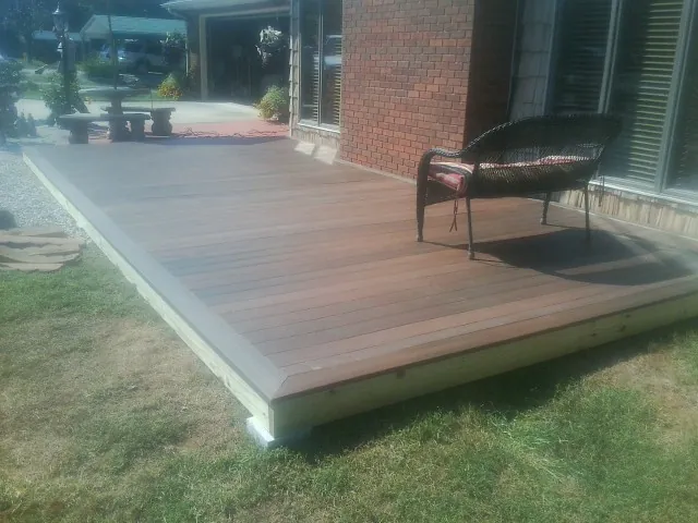 New wood deck and wicker chair beside a brick house in Petersburg